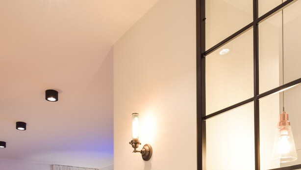A modern living room with a light blue cabinet, a floor lamp, and a large window with a view of the outside. - ShortStayPoland Kieslowskiego - B41 (Warsaw)