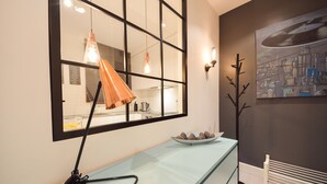A modern kitchen with a large window, a light blue countertop, and a bowl of fruit. - ShortStayPoland Kieslowskiego - B41 (Warsaw)