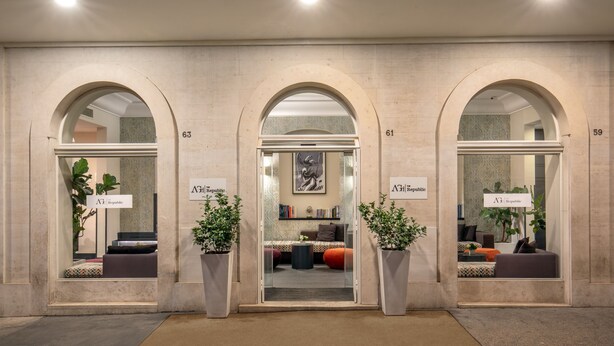 A hotel lobby with three arched doorways, each labeled with a room number and a sign indicating the hotel name. - The Republic Hotel (Rome)