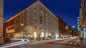A multi-story hotel with a classic architectural style, featuring a central entrance with arched windows and a prominent sign. - The Republic Hotel (Rome)