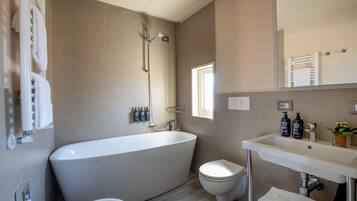 A modern bathroom with a freestanding bathtub, a toilet, and a sink.
