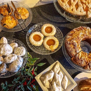 Une variété de produits de boulangerie sont disposés sur une table, notamment des tartes, des scones et des viennoiseries.