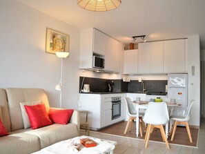 A modern apartment with a living room, kitchenette, and dining area. - Le Lavandou: 1-BR apartment, sleeps 4, terrace, pets allowed, optional parking (Le Lavandou)