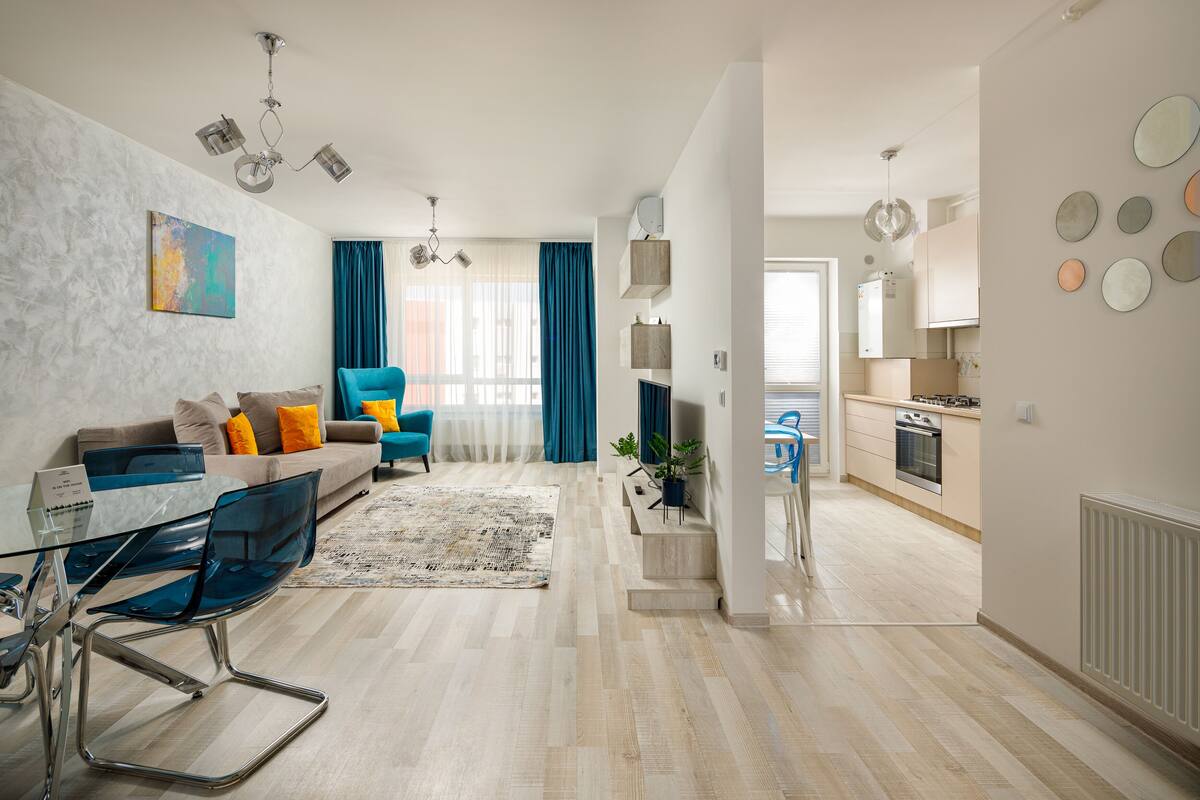 A modern apartment with a living room, dining area, and kitchen.
