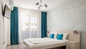 A modern bedroom with a bed, bedside tables, and a TV mounted on the wall. - Brasov Holiday Apartments (Brasov)