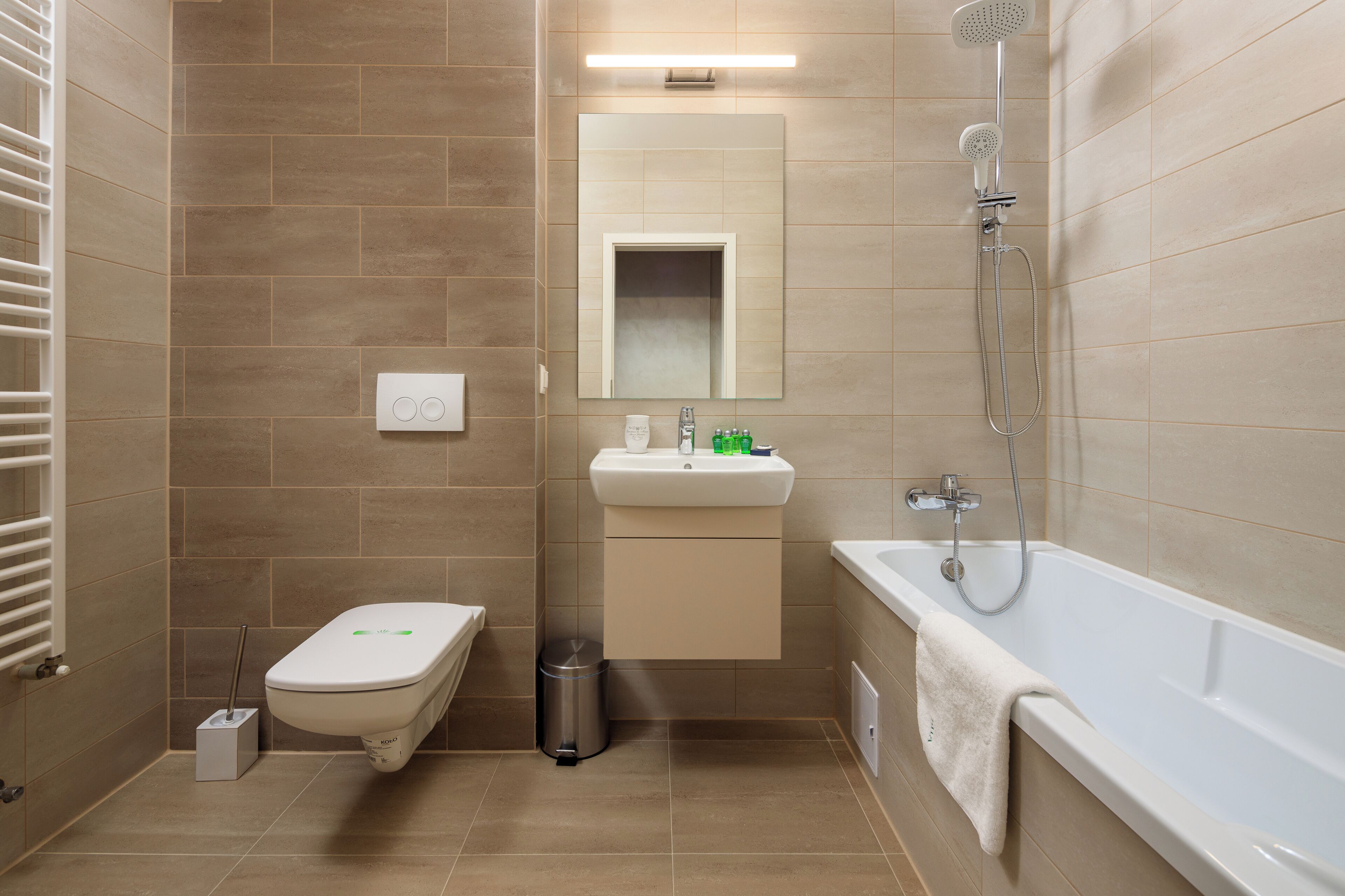 Une salle de bain moderne équipée de toilettes, d’un lavabo et d’une baignoire.