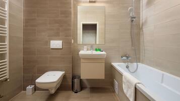 Une salle de bain moderne équipée de toilettes, d’un lavabo et d’une baignoire.