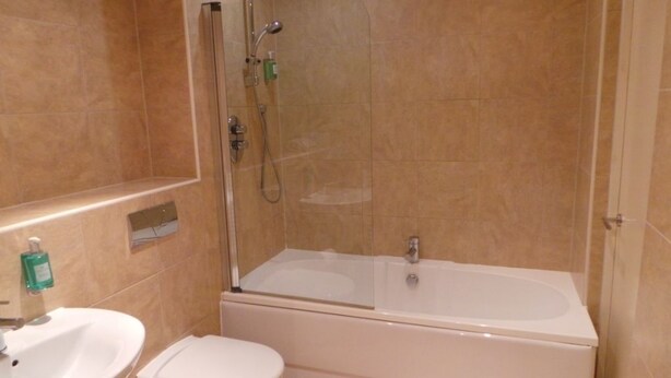 A bathroom with a shower, a sink, and a toilet. - City Crash Pad - West Street Apartments (Sheffield)