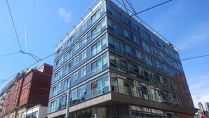A modern multi-story building with large windows and a corner entrance.