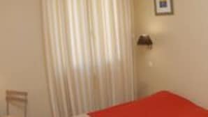 A room with a bed, a chair, and a window with curtains. - Hôtel les Terrasses du Rove (Le Rove)
