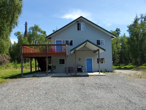 A two-story house with a covered porch and a wooden deck.