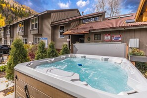 Un jacuzzi est installé devant un bâtiment sur lequel est apposée une pancarte indiquant qu’il est interdit d’y pénétrer et qu’il n’y a pas de sauveteur en service.
