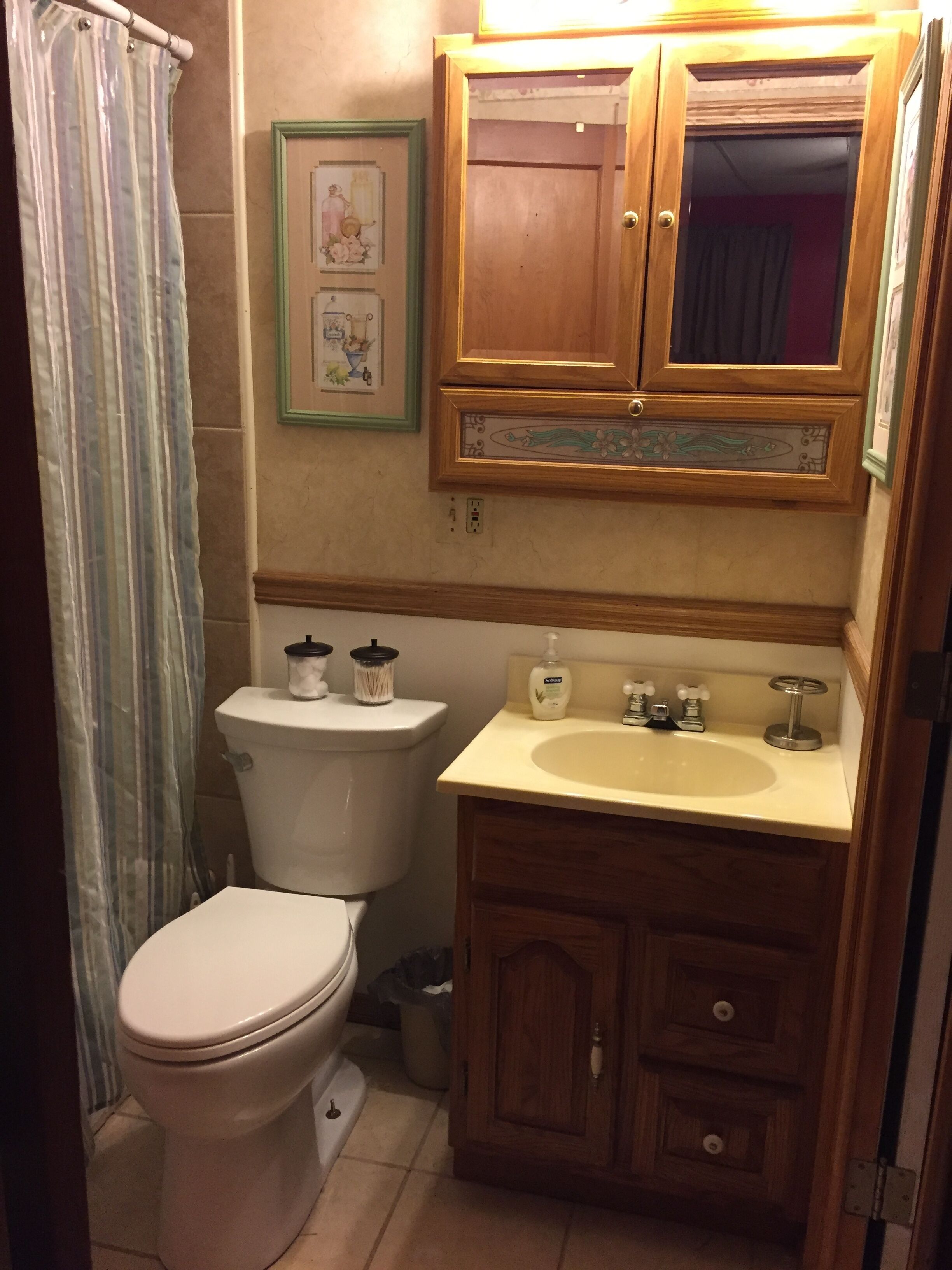 Ein Badezimmer mit Toilette, Waschbecken und Holzschränken.
