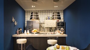 Una cocina moderna con una isla central, taburetes de bar y una mesa de comedor preparada para cuatro.