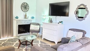 A living room with a fireplace, a television, and a sofa.