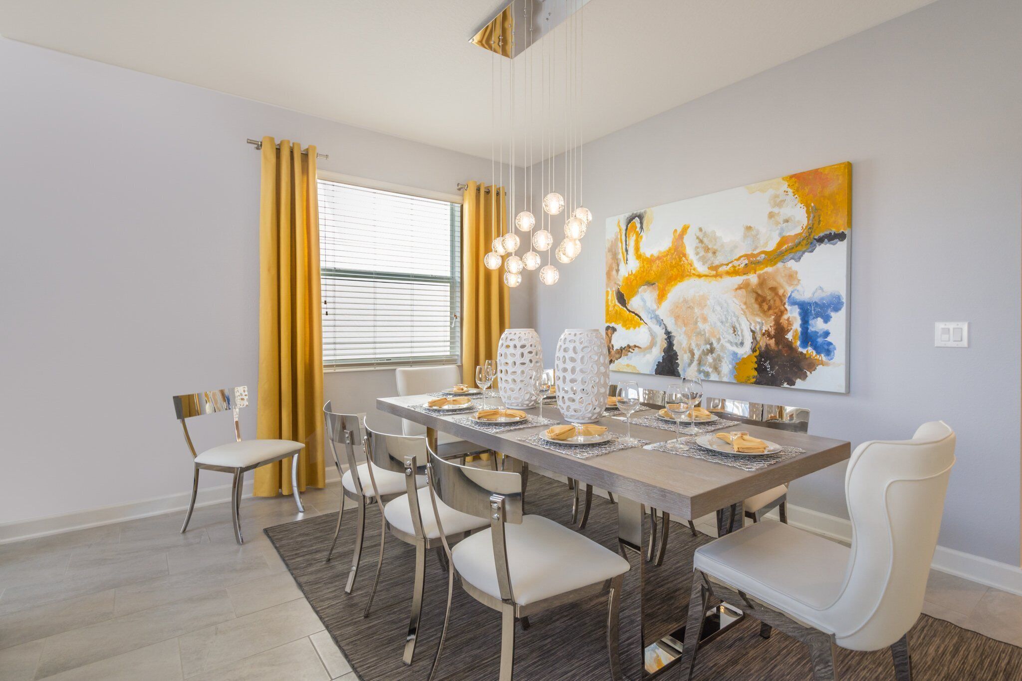 A dining room with a long table, six chairs, and a large abstract painting on the wall.