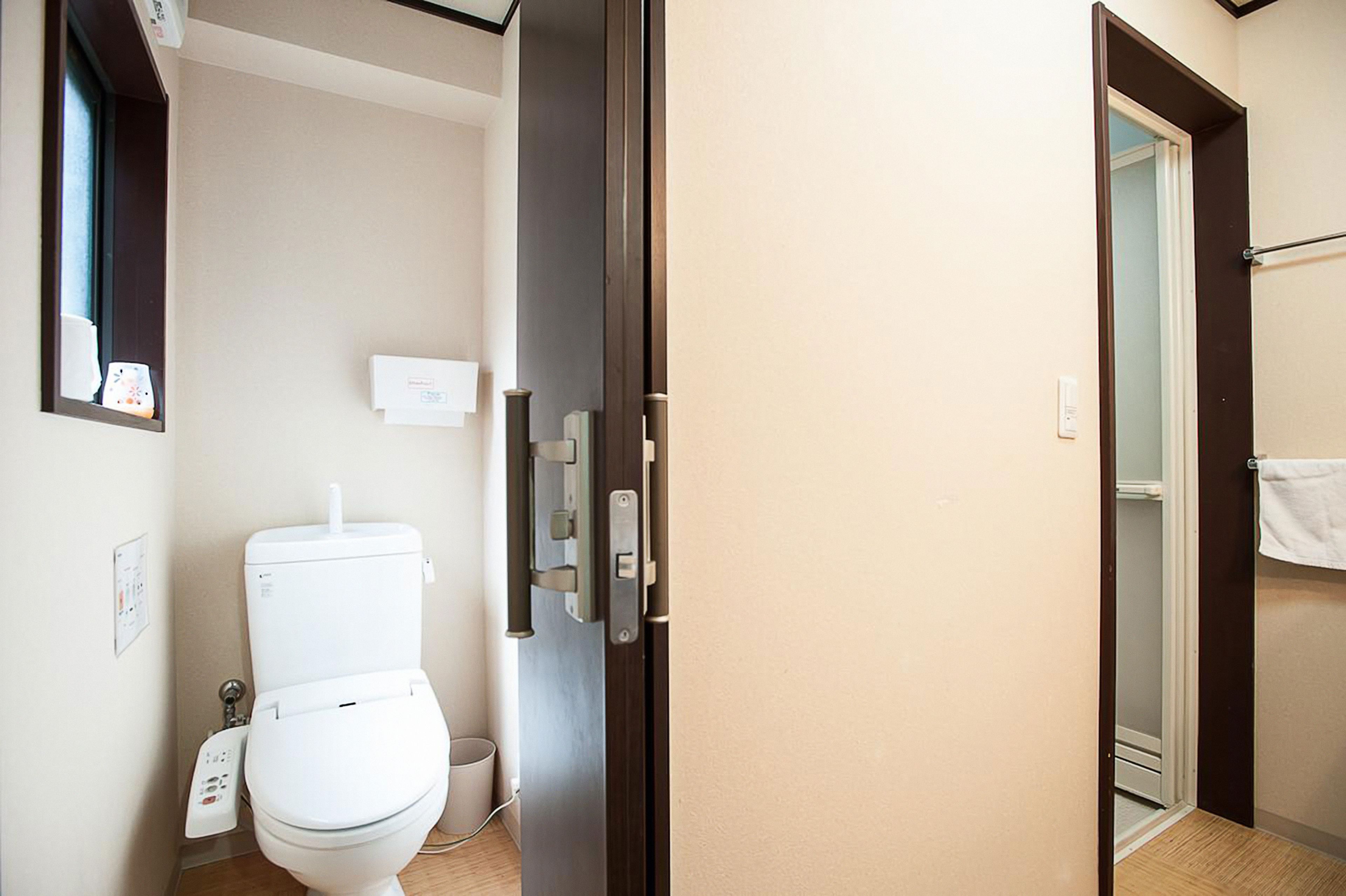 A modern bathroom with a toilet, a shower area, and a towel rack.
