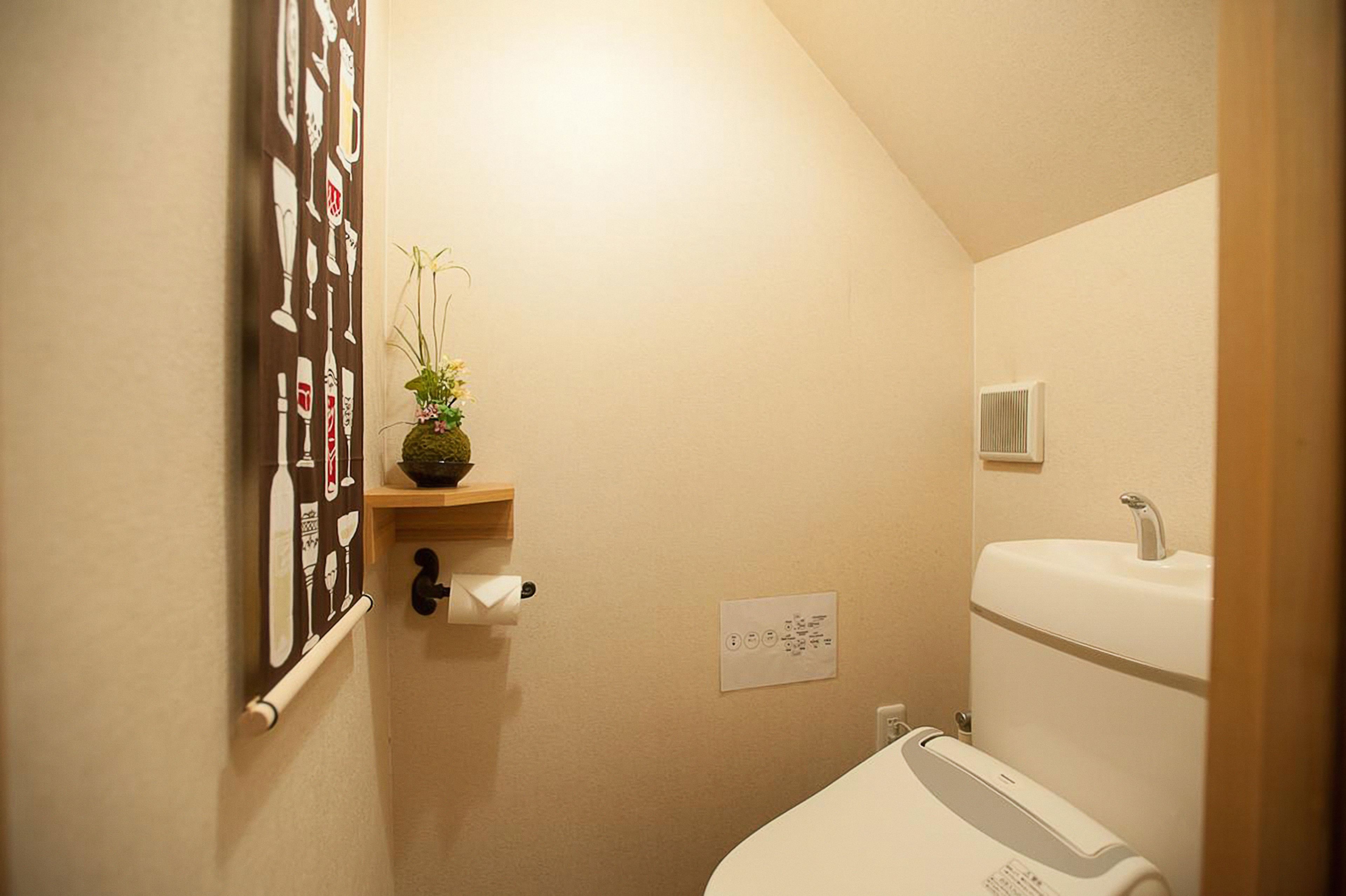 A small bathroom with a toilet, sink, and a towel rack.
