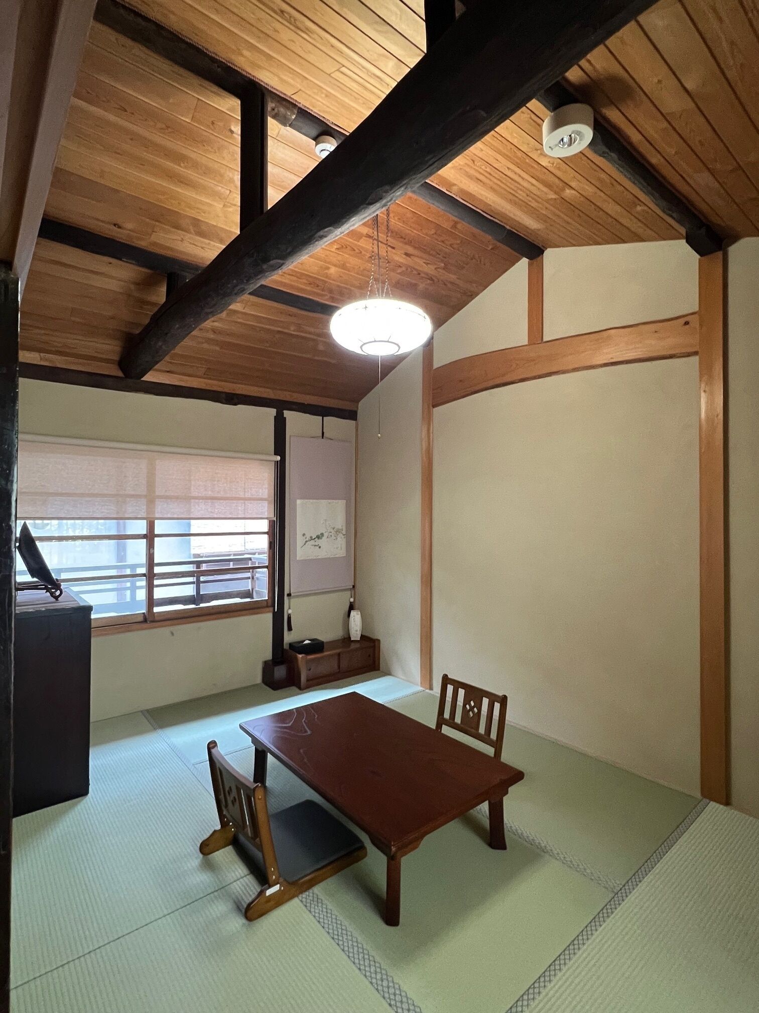 Una habitación japonesa tradicional con suelo de tatami, una mesa de madera baja y una puerta corredera.