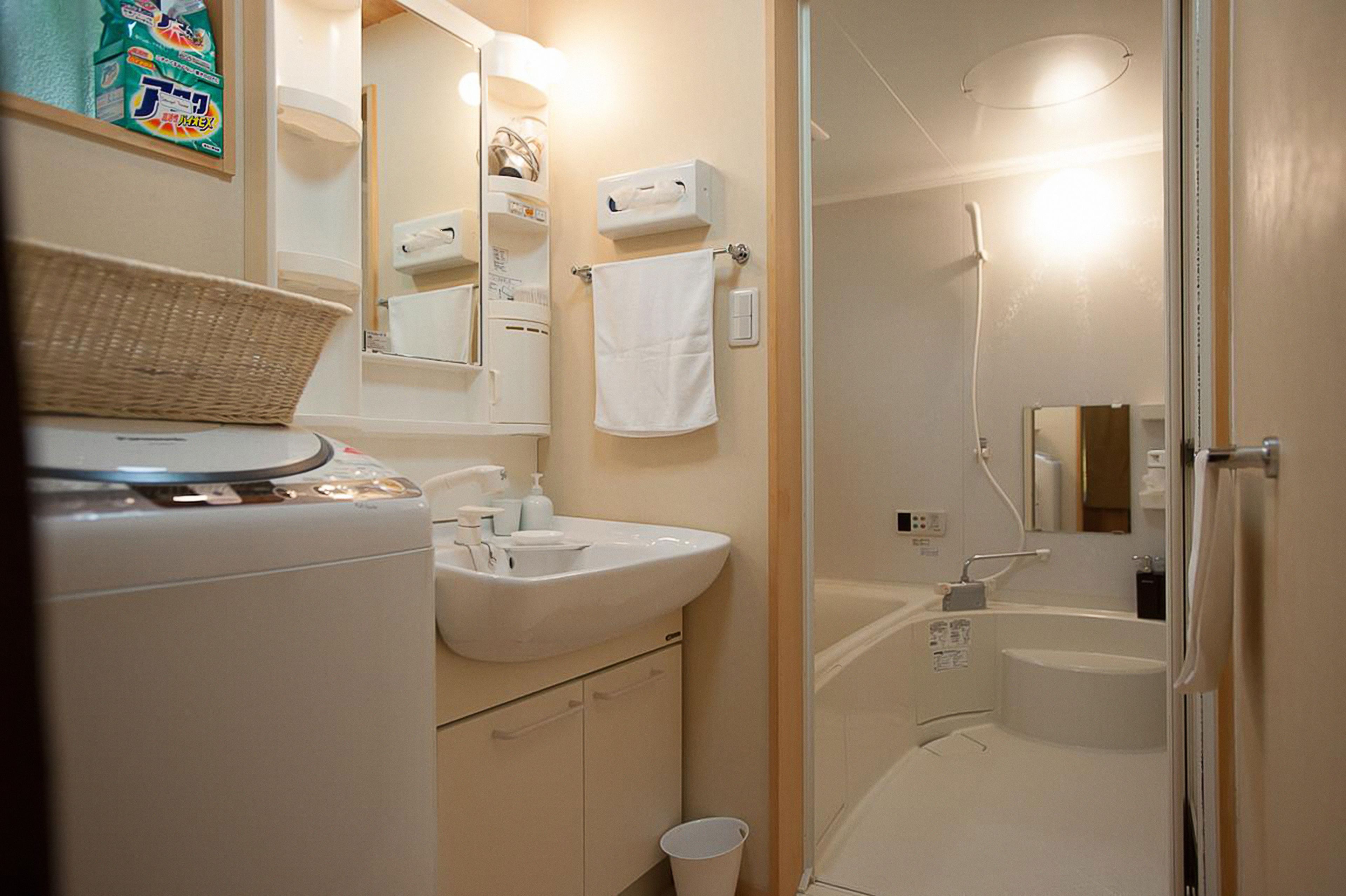 A modern bathroom with a sink, mirror, and shower.
