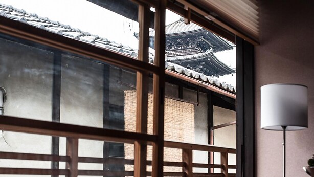 A traditional Japanese room with tatami flooring, a shoji screen, and a view of a traditional building. - Kiyomizu Machiya Inn (Kyoto)