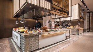 Een buffet met diverse gerechten en een kok die bereidt.