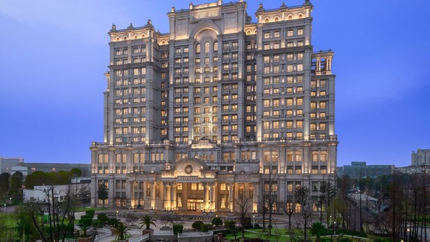 Un grand hôtel à plusieurs étages, doté d’une entrée imposante et d’une façade symétrique.