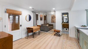 A modern apartment with a dining area, sofa, and kitchen. - Charming Historic 1BR w/ Private Porch + Free Parking (Charleston)