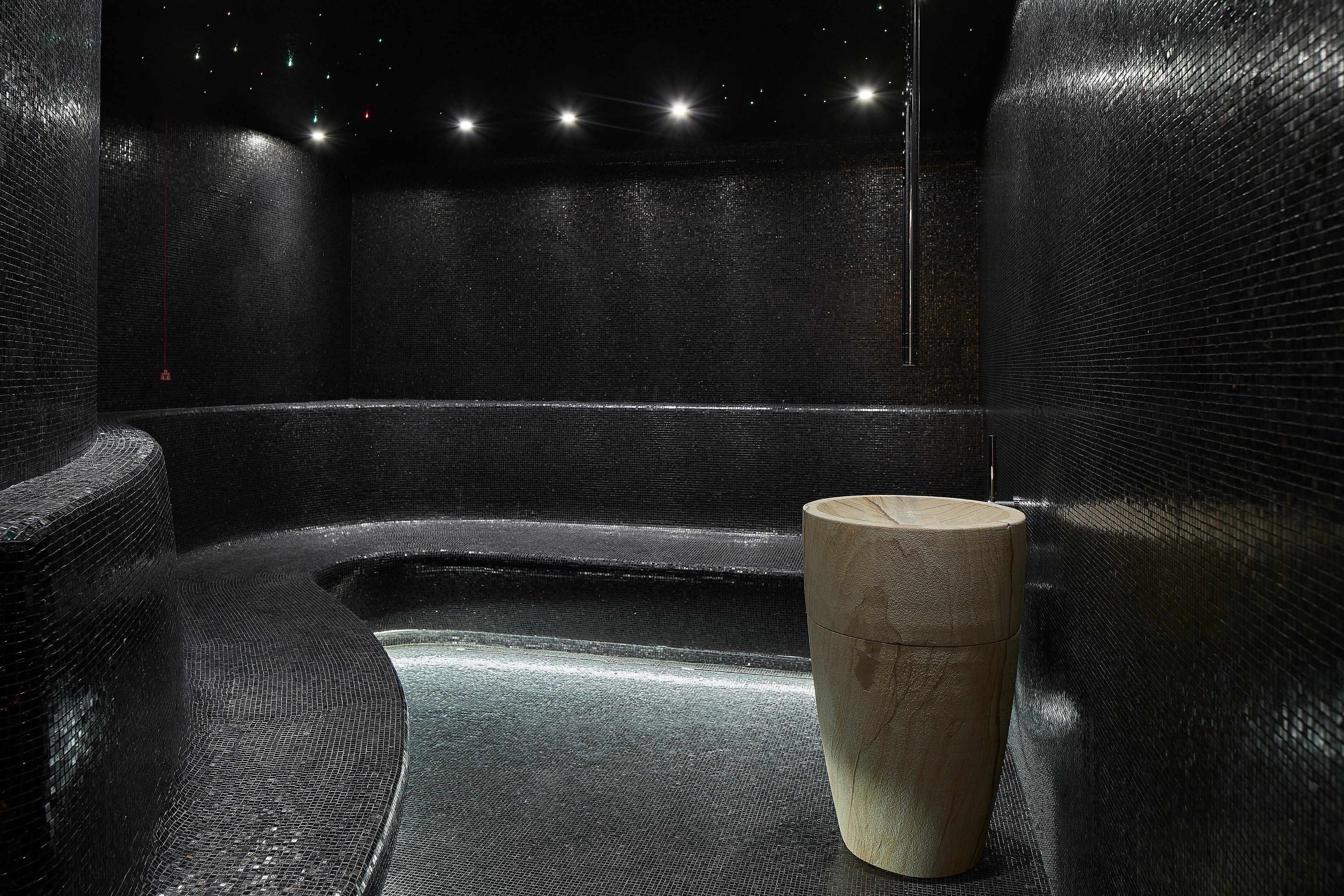 A room with a textured wall, a cylindrical object, and a seating area.