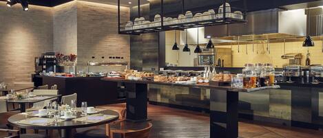 Een modern restaurant met een centrale bar, diverse zitmogelijkheden en verschillende presentaties van eten en drinken.