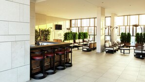 A spacious indoor area with a bar, seating, and large windows.