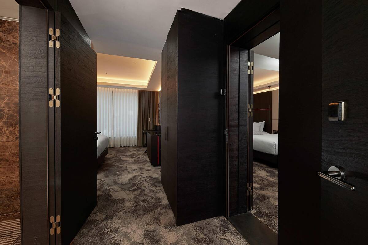 Una habitación de hotel con una cama, un escritorio y un espejo.