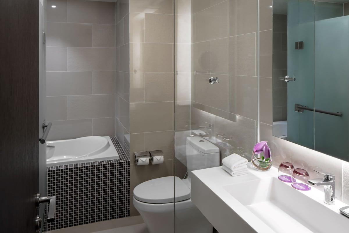 A modern bathroom with a bathtub, toilet, and sink.