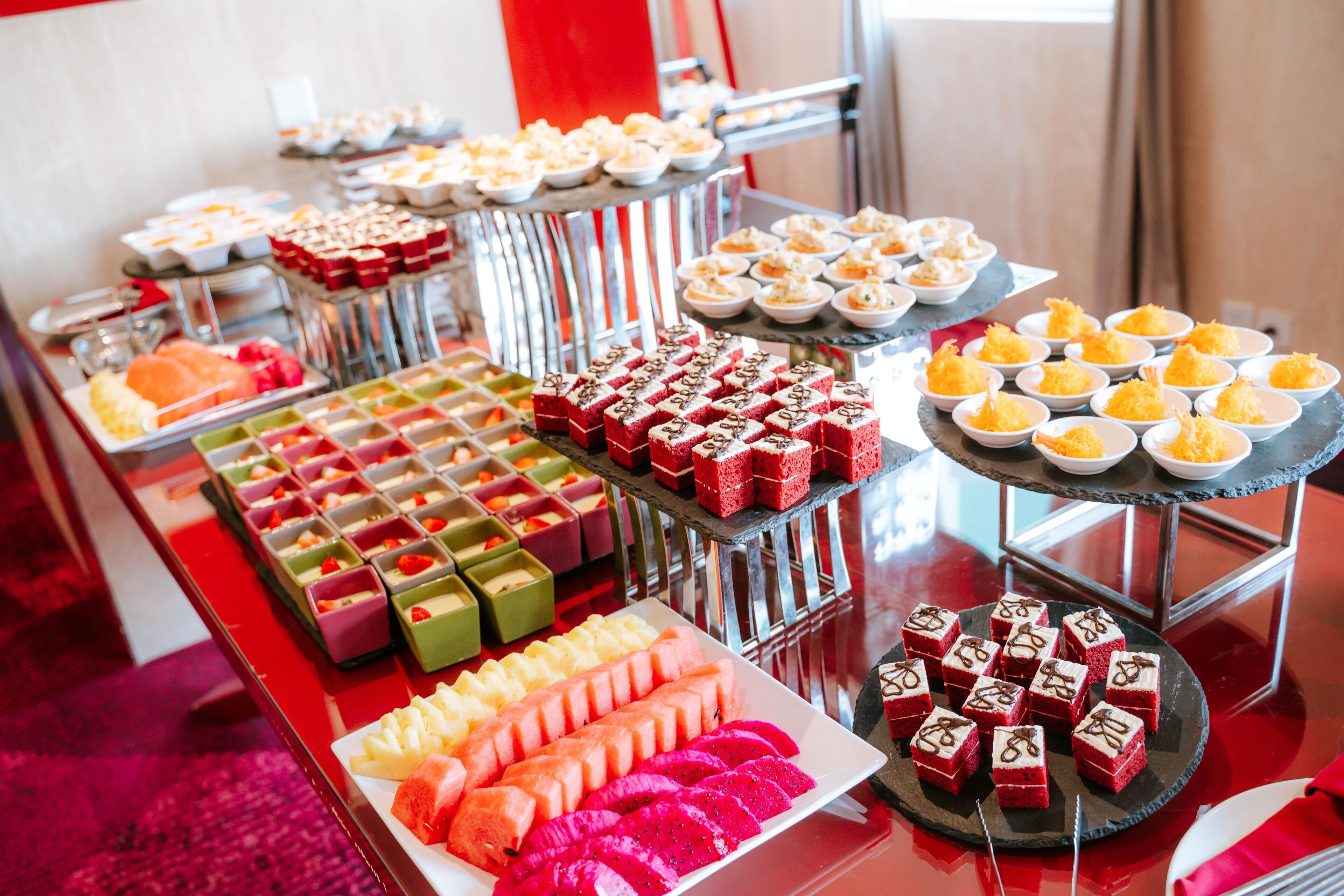 A buffet with various desserts and fruits.