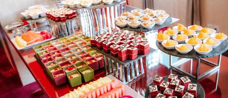 A buffet with various desserts and fruits.