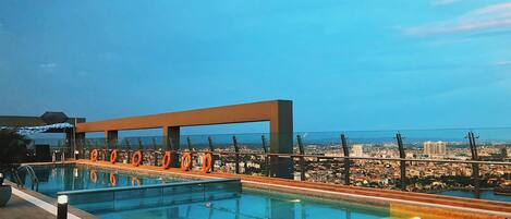 A rooftop pool with a clear view of the cityscape in the background.
