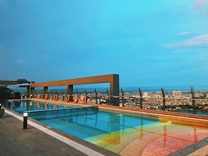 A rooftop pool with a clear view of the cityscape in the background.