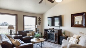 A living room with a fireplace, leather sofas, a coffee table, and a flat-screen TV. - Within Minutes Of BYU, Temples, Skiing  Sleeps 18 (Vineyard)