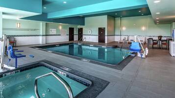 Una piscina techada, sillones reclinables de piscina