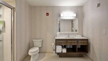 A modern bathroom with a toilet, sink, and mirror.