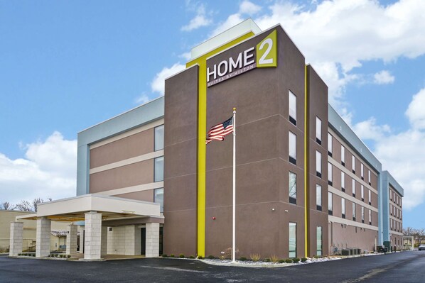 Un edificio de hotel moderno con un letrero que dice "HOME 2" y una bandera estadounidense.