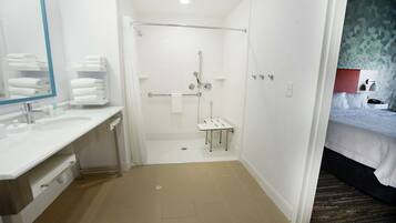 Une salle de bain moderne équipée d’une douche, d’un lavabo et d’un miroir.