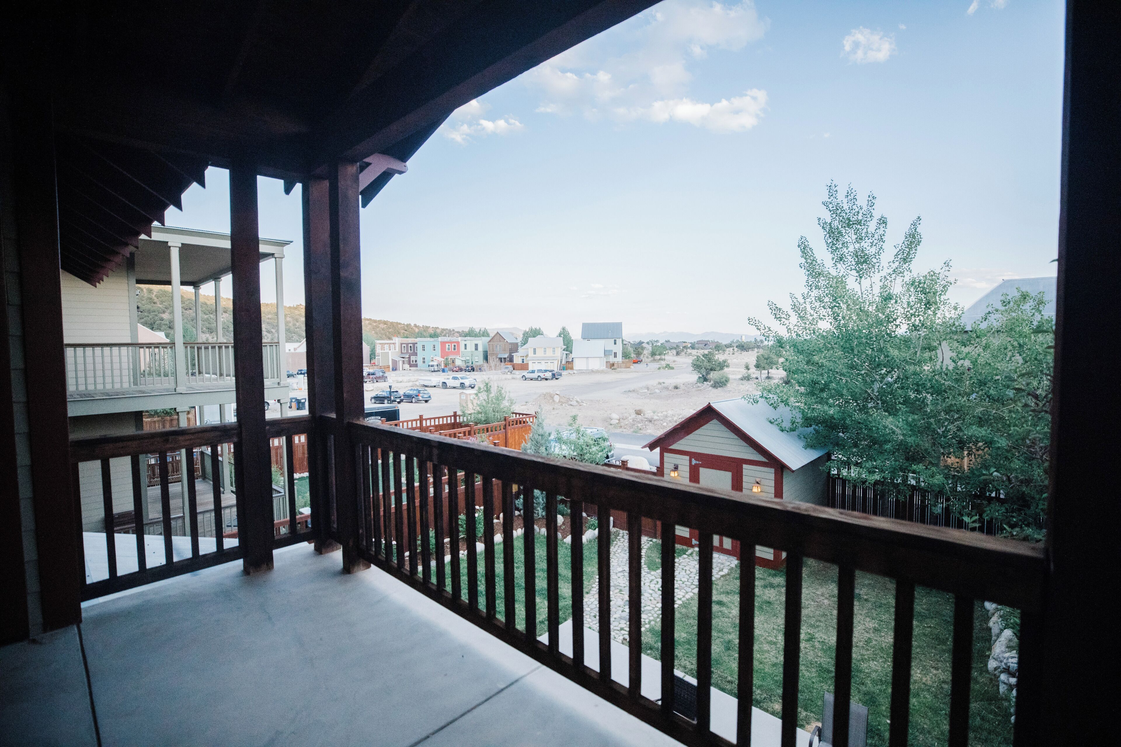 Un balcó amb vista a una zona residencial, amb cases i un pàrquing.