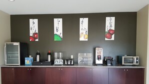 Eine Küchenzeile mit Kühlschrank, Kaffeemaschine, Mikrowelle und Kaffeeautomaten.