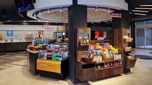 A food kiosk with a variety of snacks and beverages, a coffee station, and a sign for 'eat & sip'.