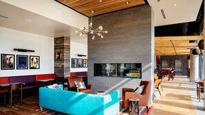 Un moderno vestíbulo con sofá azul, suelo de madera y pared de piedra.