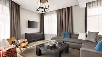 Una sala de estar moderna con sofá, mesa de centro, televisor y chimenea.