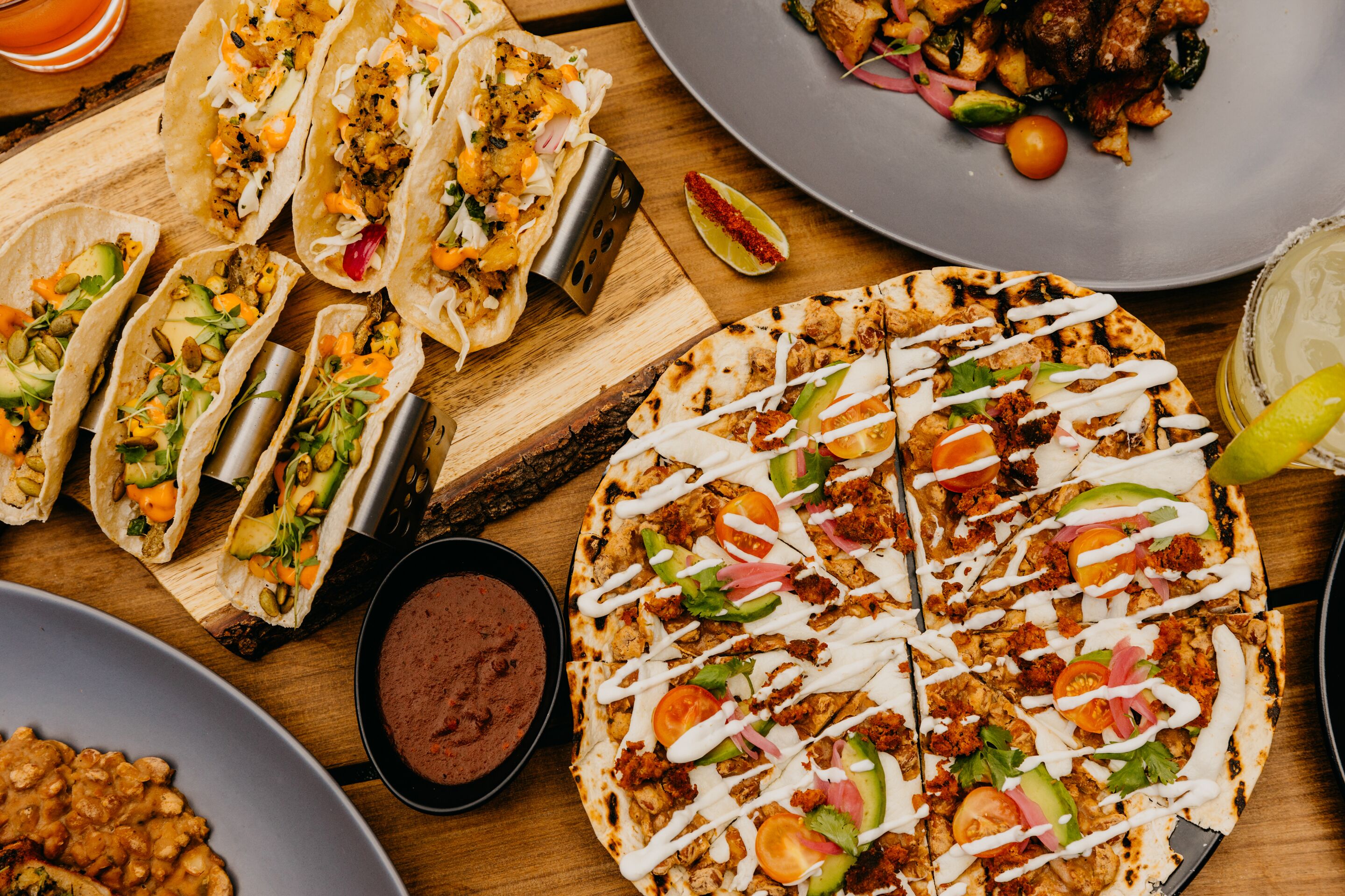 Verschiedene Gerichte, darunter Tacos, Pizza und eine Schüssel Bohnen.