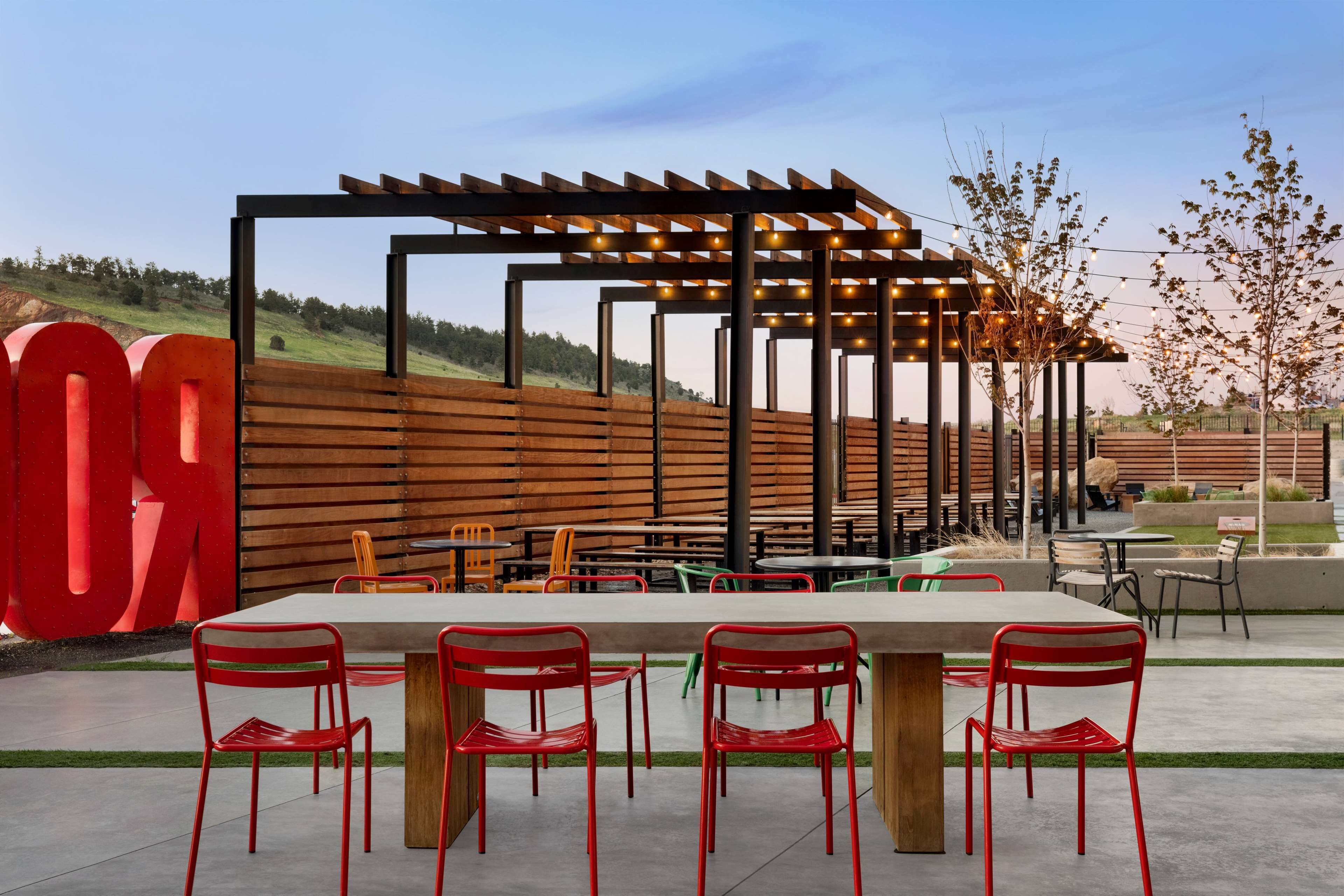 An outdoor seating area with a pergola, tables, and chairs.