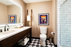Bathroom features a large mirror, white sink, and a glass shower enclosure.